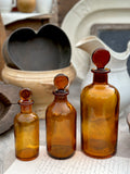 Trois flacons de pharmacie anciens en verre ambré