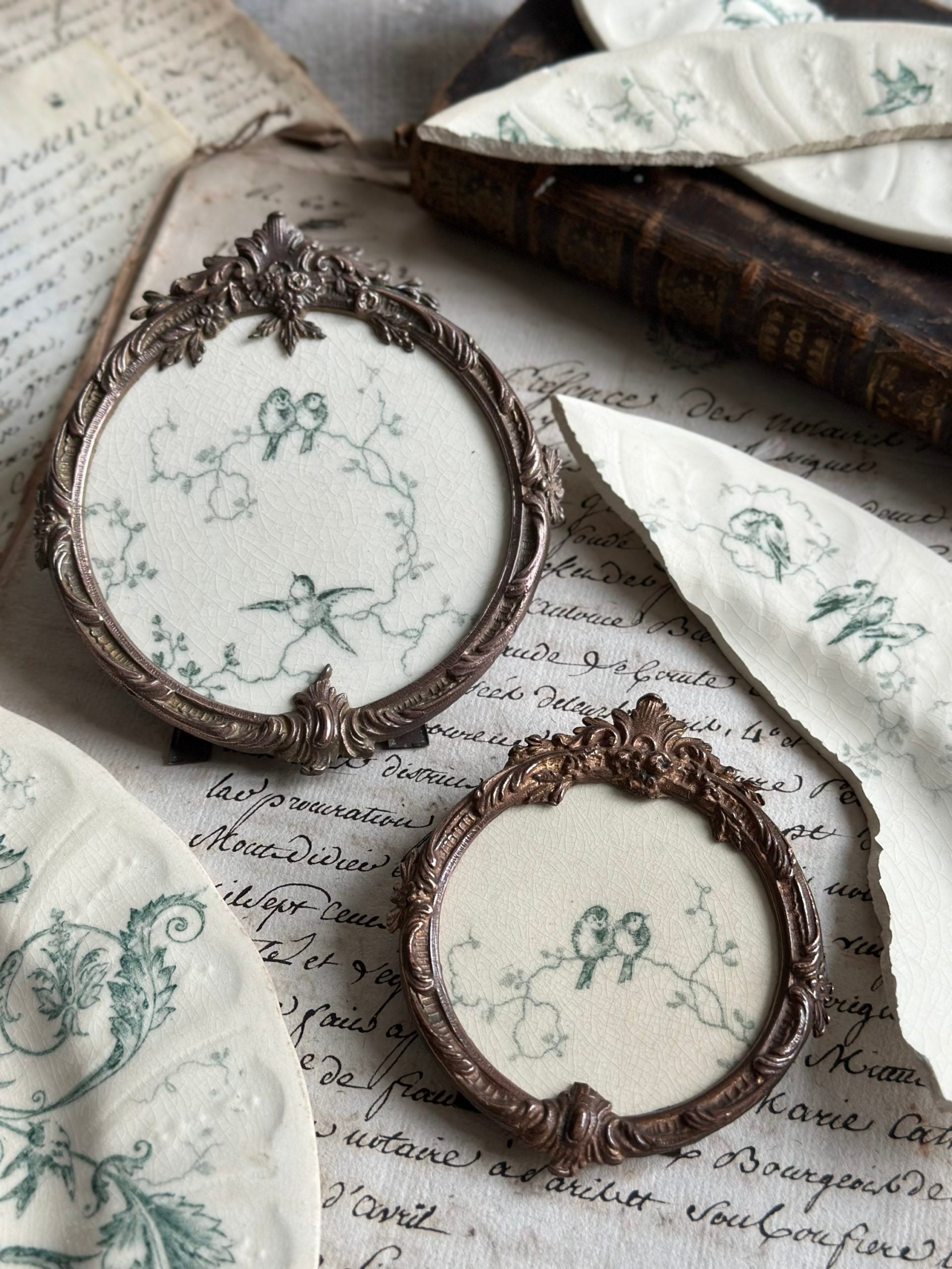 Cadre ancien rond bronze et motif terre de fer Gien Rinceaux