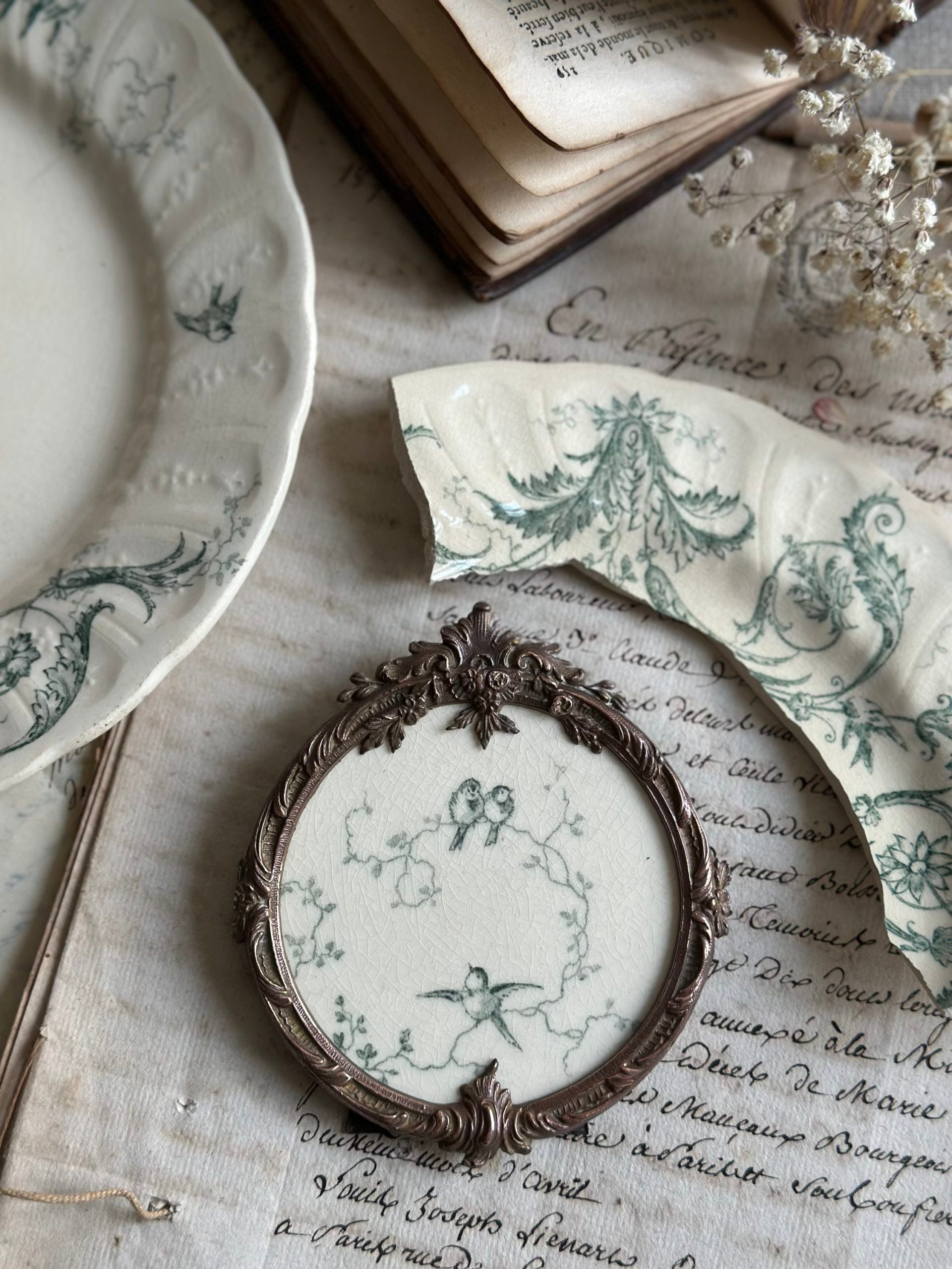 Cadre ancien rond bronze et motif terre de fer Gien Rinceaux