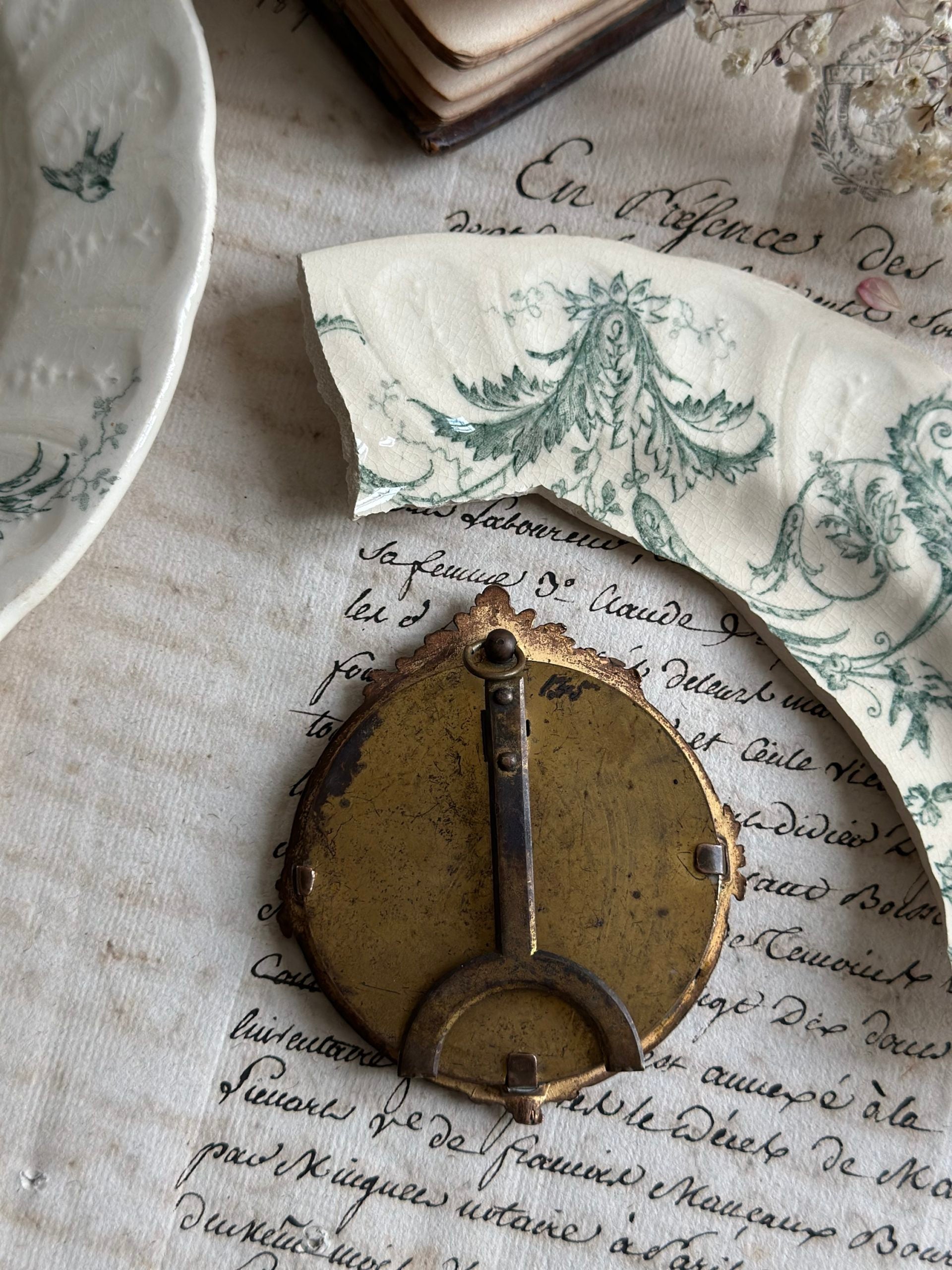 Petit cadre ancien rond bronze et motif terre de fer Gien Rinceaux