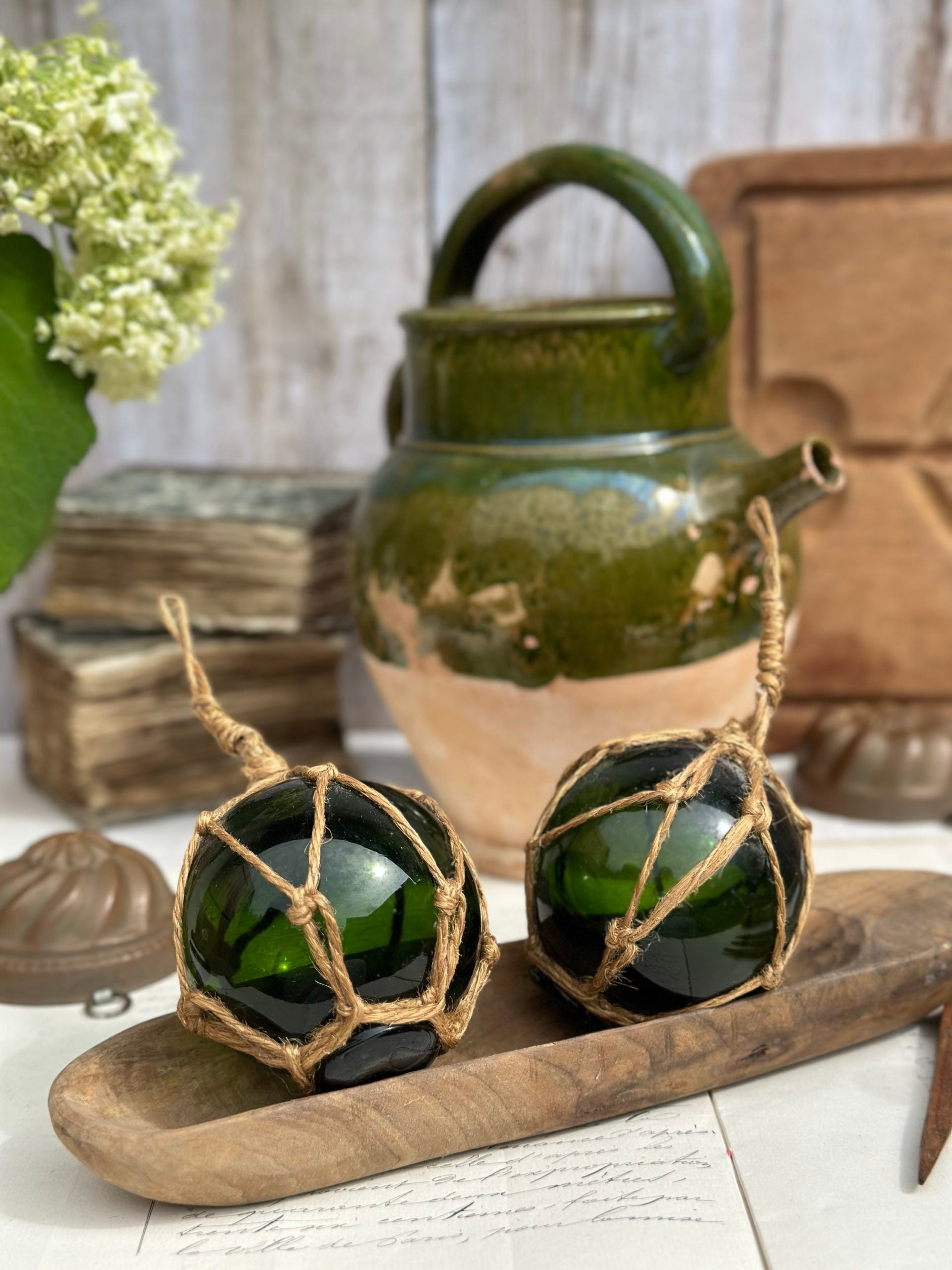 Two antique blown-glass fishing float balls with rope net