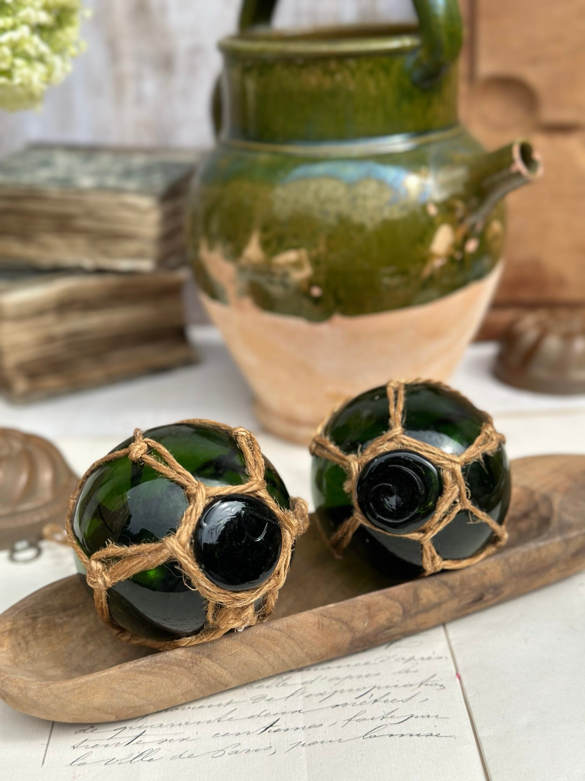 Two antique blown-glass fishing float balls with rope net